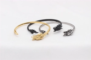 Nahaufnahme von Drachenkopf-Armbändern in Gold, Silber und mattem Schwarzstahl