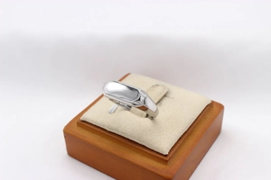 Bague rectangulaire en acier argenté poli présentée sur un support de bijoux élégant