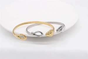 Detail of vintage snake titanium steel open bracelets in polished gold and silver finish