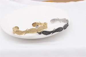 Dettaglio della trama piuma vintage su bracciali in acciaio inossidabile oro e argento