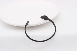 Macro shot of minimalist black steel open bangle with smooth finish and drop shaped ends