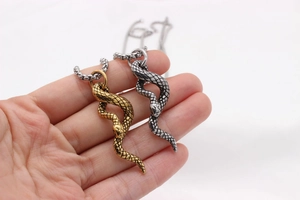 Macro shot of cobra pendant showing detailed scales and head in gold and silver finish