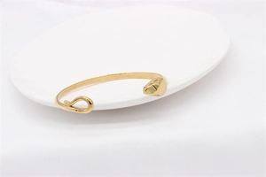 Detailed view of polished gold open cuff bracelet with irregular artistic design