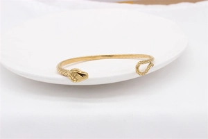 Detailed view of golden snake-shaped open bracelet featuring intricate scale texture