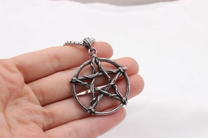 Gros plan du pendentif pentagramme en acier rétro avec texture de fil vintage pour hommes