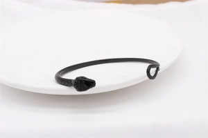Detail shot of matte black snake cuff bracelet showing intricate realistic scale textures
