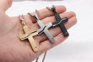 Macro view of men's cross pendant in gold, silver and black with faux leather texture