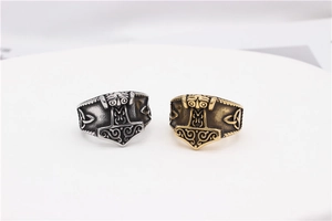 Detail of Viking Mjolnir rings in silver and gold finish with Celtic knot engravings