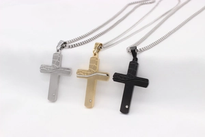 Close-up of retro cross necklaces in silver, gold, and black with unique cracked texture