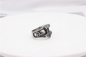 Macro view of vintage Mjolnir ring featuring intricate Nordic engraving and Triquetra symbol