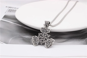 Macro detail of Viking Celtic knot pendant with vintage silver finish on white ceramic