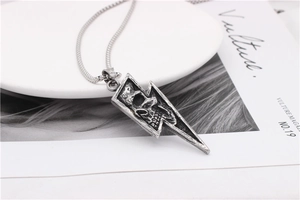 Detailed view of vintage lightning bolt pendant with skull relief in blackened steel finish