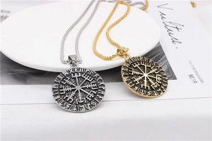 Detailed close-up of Viking Vegvisir compass pendant with Nordic runes in silver and gold