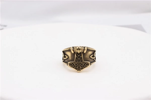 Detailed close-up of vintage bronze Mjölnir ring with intricate Celtic knot patterns