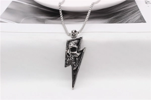 Detail of vintage silver lightning bolt pendant necklace with realistic skull carving