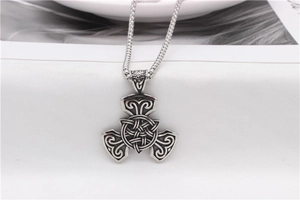 Close-up of vintage silver Celtic knot pendant with oxidized finish and box chain