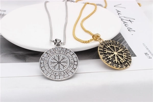 Detailed view of Viking Vegvisir compass pendants in gold and silver with rune engravings