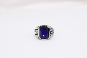 Macro shot of rectangular blue gemstone set in a vintage titanium steel ring with filigree