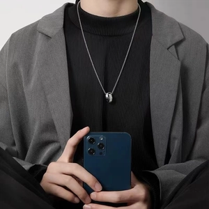 Close-up of a men's double-ring interlocking pendant necklace with pave-set cubic zirconia