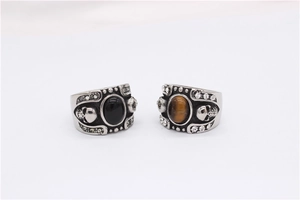 Detailed shot of retro gothic rings featuring skull relief and oval gemstones in silver finish