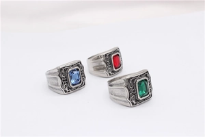 Détail de bagues chevalières vintage avec de grandes pierres rouge, vert et bleu roi
