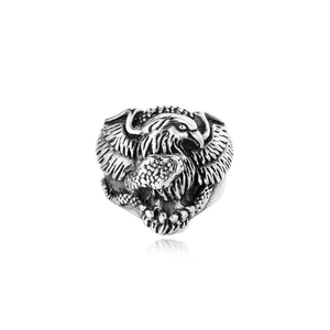 Macro detail of vintage silver eagle ring featuring intricately carved feathers and metal texture