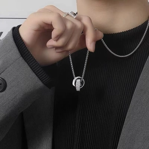 Detail of double ring pendant necklace with crystals worn on a grey blazer