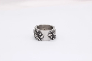 Gros plan d'une bague vintage en acier titane avec motifs de poissons doubles en relief