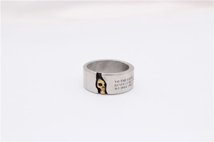 Close-up of vintage steel skull ring with engraved quote on a brushed metal band