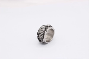 Détail macro d'une bague rétro en acier titane avec motif carpe koi en relief
