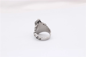 Macro detail of vintage stainless steel ring with intricate baroque floral engravings