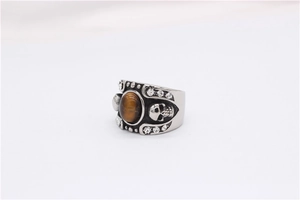 Detail of vintage skull ring featuring tiger eye stone and crystal accents on steel
