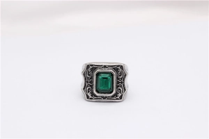 Gros plan détaillé d'une bague rétro en argent sertie d'une émeraude carrée et gravures