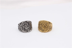 Detail view of gold and silver Masonic rings with compass and square emblem on white background