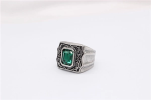 Vue macro d'une bague vintage en acier avec pierre verte taille émeraude et gravure
