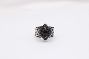 Macro shot of retro steel ring featuring a black gemstone and intricate relief carving