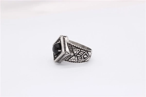 Detail of vintage silver titanium steel ring featuring black onyx inlay and carvings