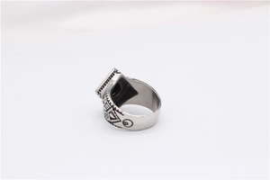 Top down detail view of men's vintage steel ring with tribal patterns and black inlay