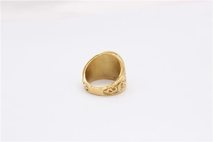 Close-up of vintage gold stainless steel ring featuring embossed floral relief patterns