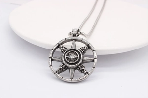 Macro shot of vintage compass pendant with star rays on a white plate
