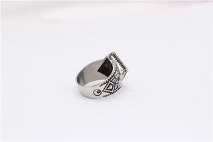 Macro detail of vintage titanium steel ring showing geometric eye engravings and square top