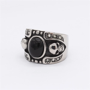 Gothic silver ring with large oval black gemstone and side skull relief details