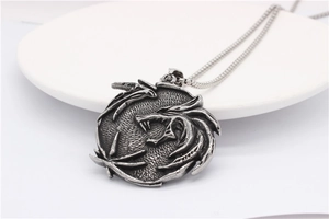 Macro close-up of a vintage silver dragon relief pendant with detailed metal engraving