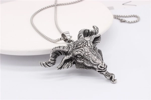 Detailed view of goat head pendant with three eyes and curved horns on bead chain