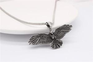 Gros plan détaillé du pendentif aigle en argent antique avec sa chaîne à billes en métal