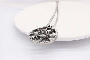Macro shot of retro stainless steel Eye of Providence pendant on a white tray