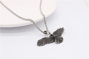 Vue détaillée du pendentif aigle avec finition argentée vintage et chaîne à maillons