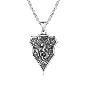 Detailed macro view of retro stainless steel dragon shield pendant with vintage oxidation