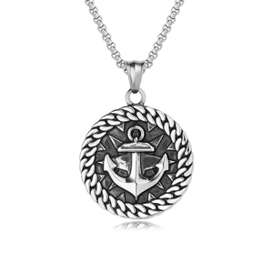Détail du pendentif nautique avec ancre et boussole sur une texture d'acier poli