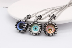 Three punk style Evil Eye pendants with skull design in blue and orange finishes